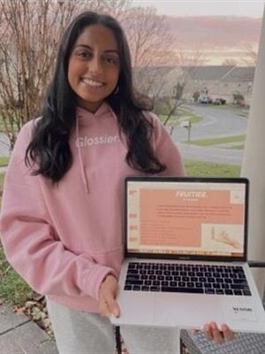 Meera Kripalu holds her laptop displaying her presentation.